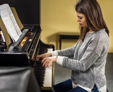 Instrumententransport Instrumententransport: Frau spielt an einem Klavier