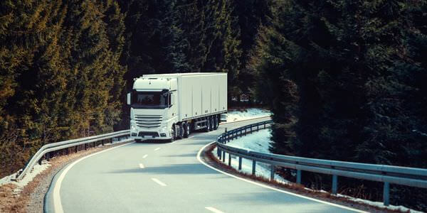 Klaviertransport Castrop-Rauxel: Lkw fährt auf einer kurvigen Straße durch den Wald