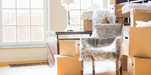 Kartons zwischen Sesseln in einem hellen Zimmer